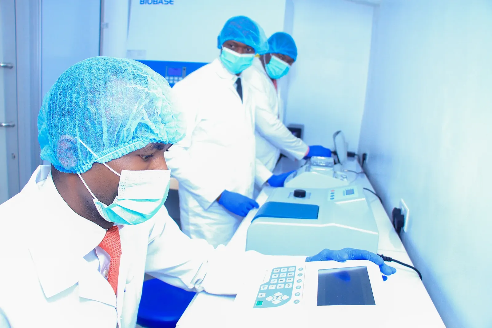 Everight scientists in full protective equipment operating real-time PCR thermocyclers in the Level 3 biosafety molecular laboratory